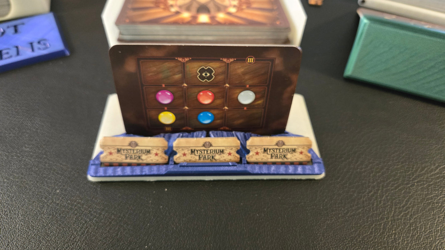 Card game component with colored stones and text on a dark surface