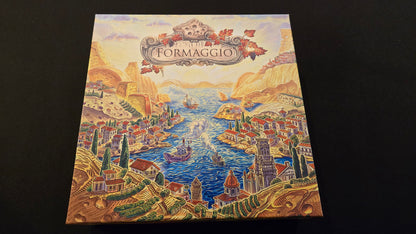 Board game box titled 'Formaggio' with a scenic illustration on a dark background
