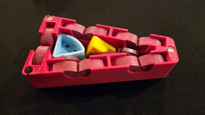 Red plastic tool with colorful components on a black background