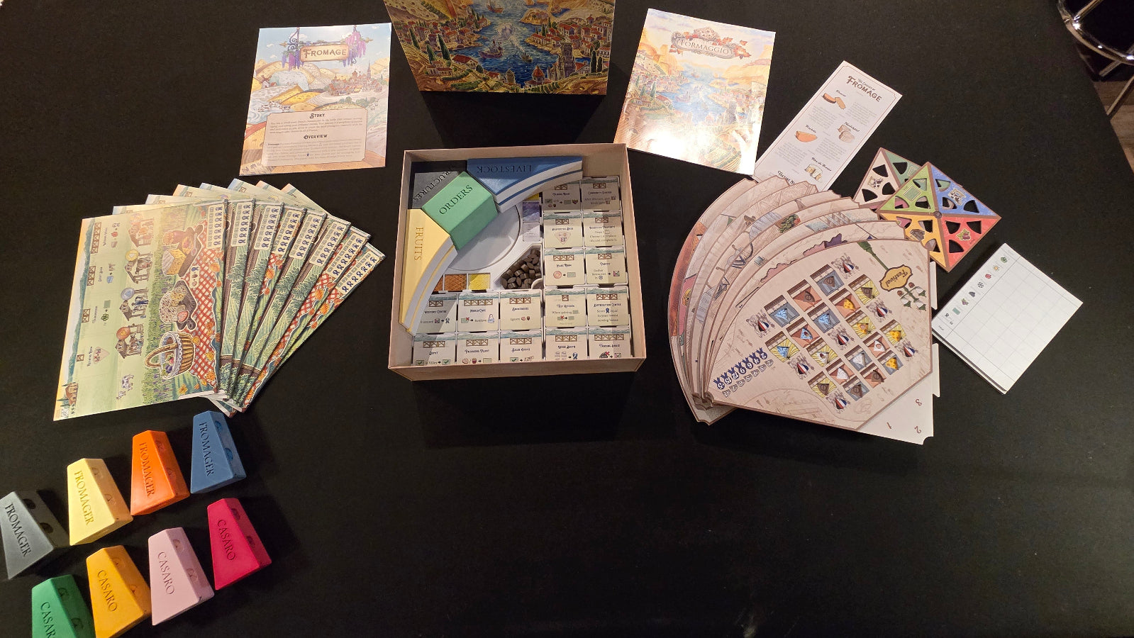 Board game components including cards and pieces on a dark surface