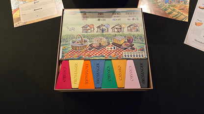 Set of colored swatches in a box with a colorful label on a black surface