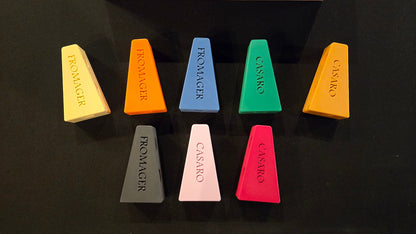 Set of colorful cheese-shaped chalks with brand names on a black background