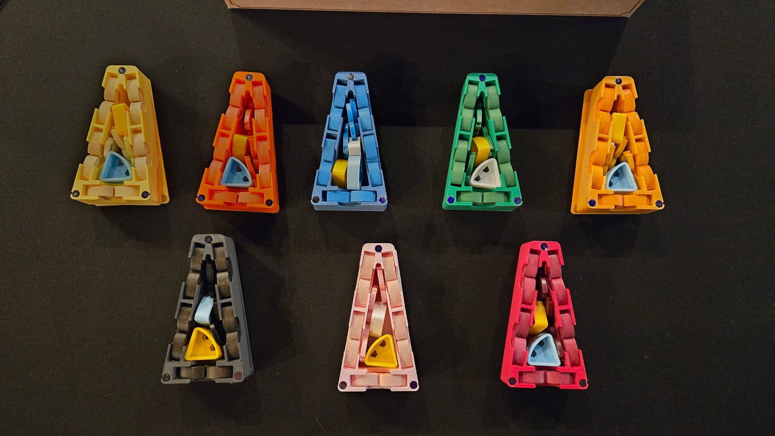 Nine colorful letter 'A' shaped objects on a black background