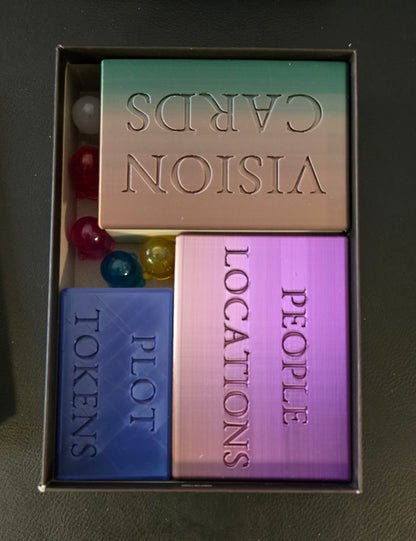 Box containing vision cards, people locations, and plot tokens on a dark surface.