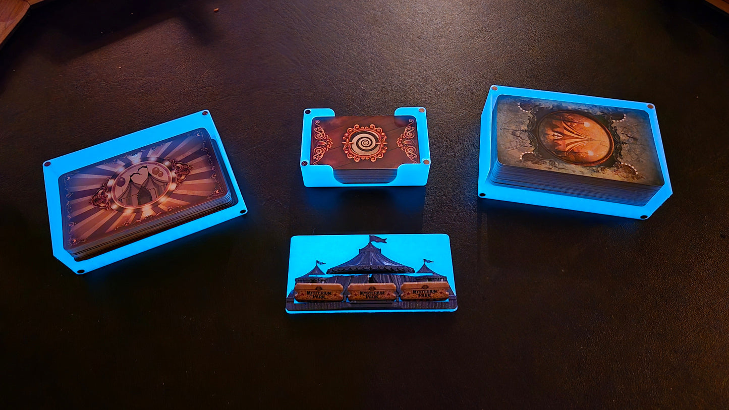 Four gaming miniatures in blue trays on a dark surface