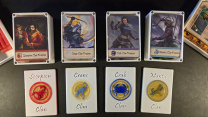 Collection of fantasy cards with characters and clan symbols on a dark surface