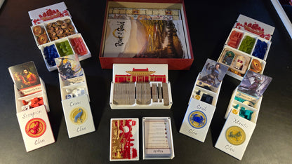 Collection of board game components including cards and boxes on a dark surface