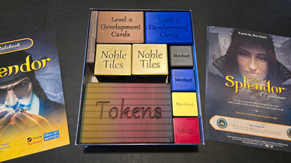 Collection of 'Splendor' game components including cards and tokens on a dark surface.