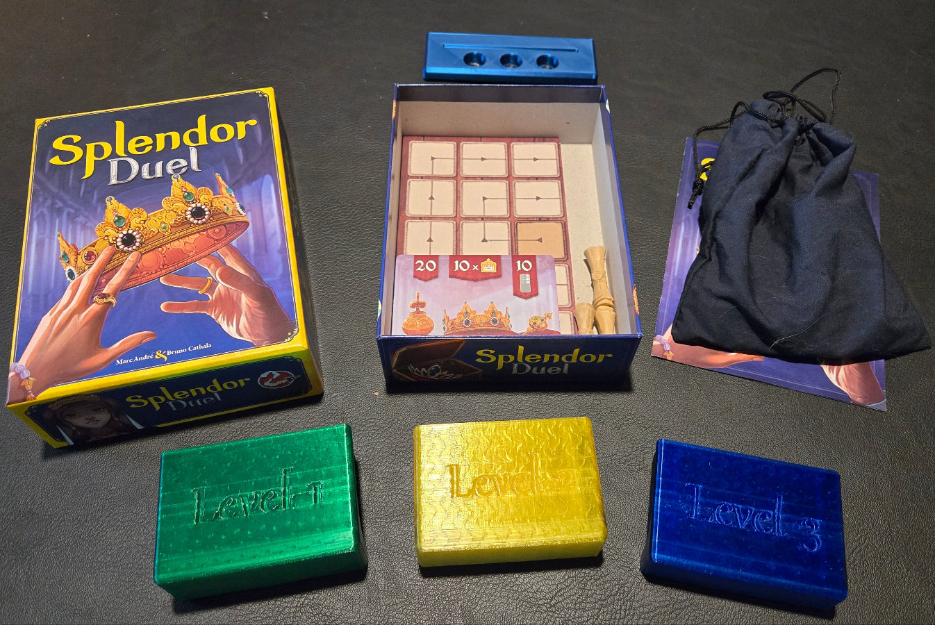 Splendor Duel board game components including box, dice, and bags on a dark surface