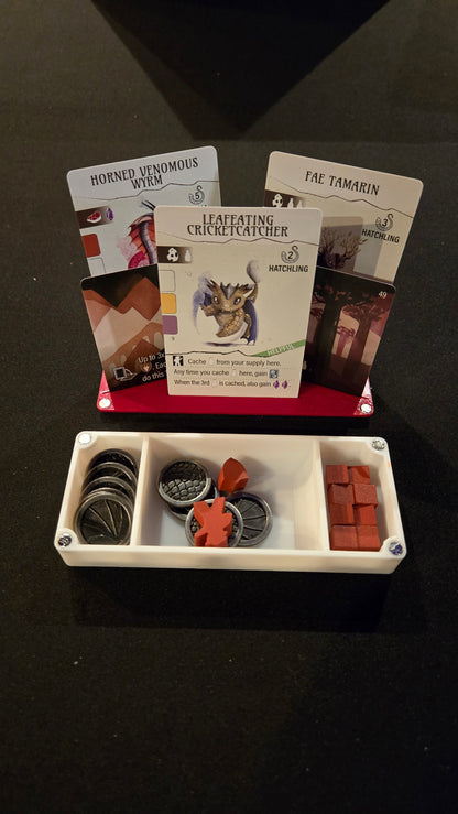 Collection of fantasy role-playing game components including cards, dice, and miniatures on a dark surface.