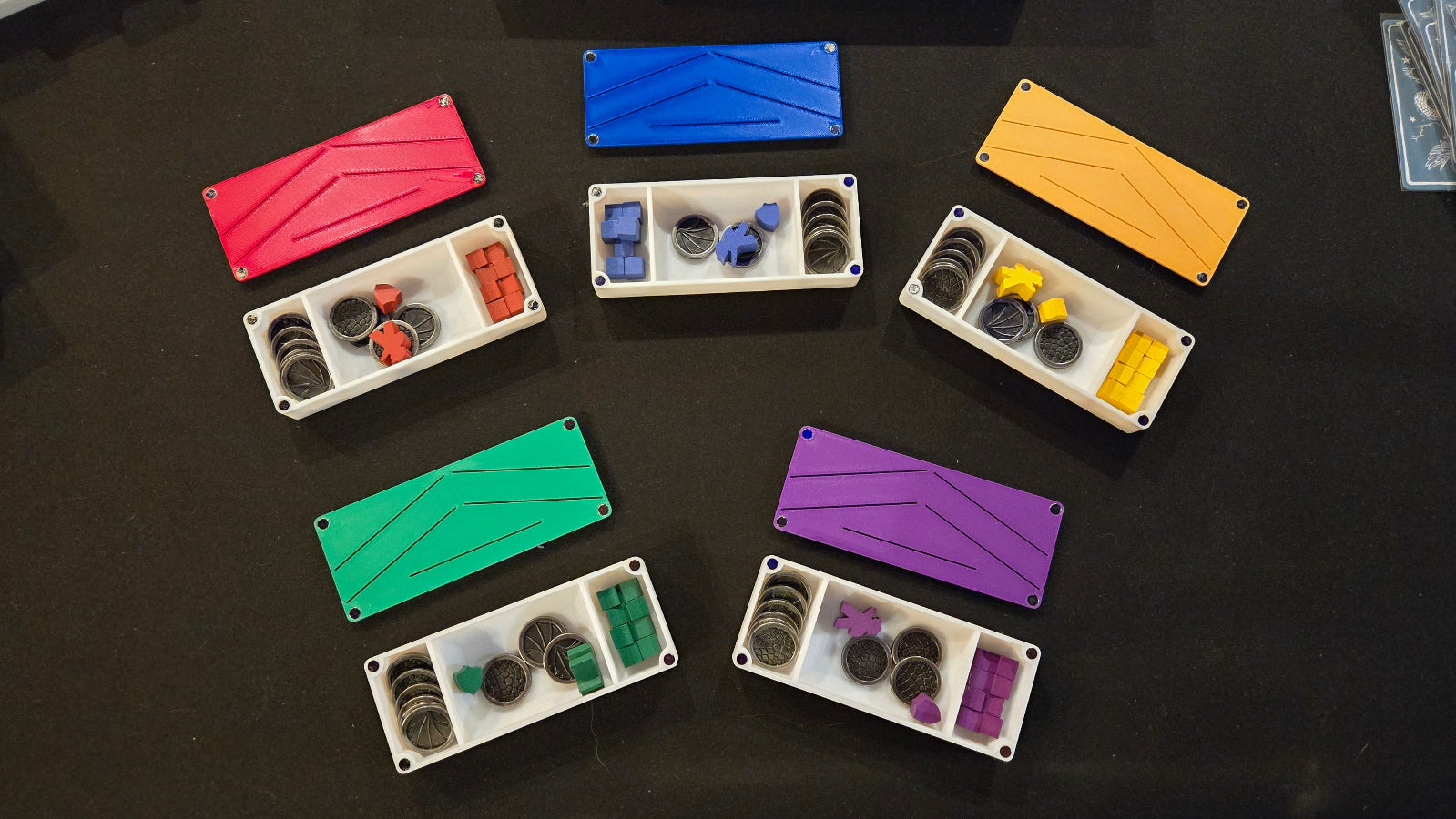 Colorful plastic trays with compartments on a black surface