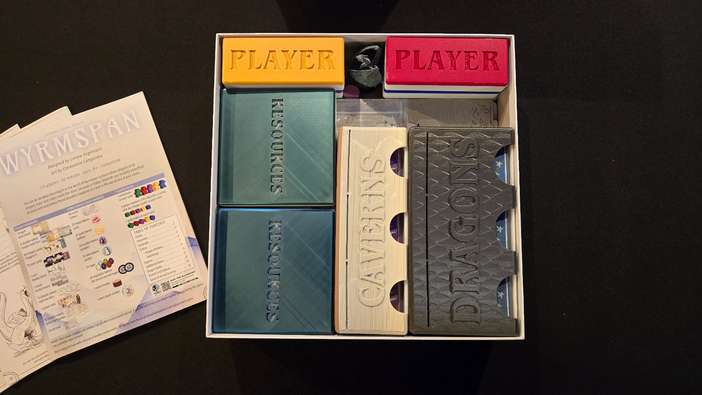 Card game components including cards and a box on a dark surface