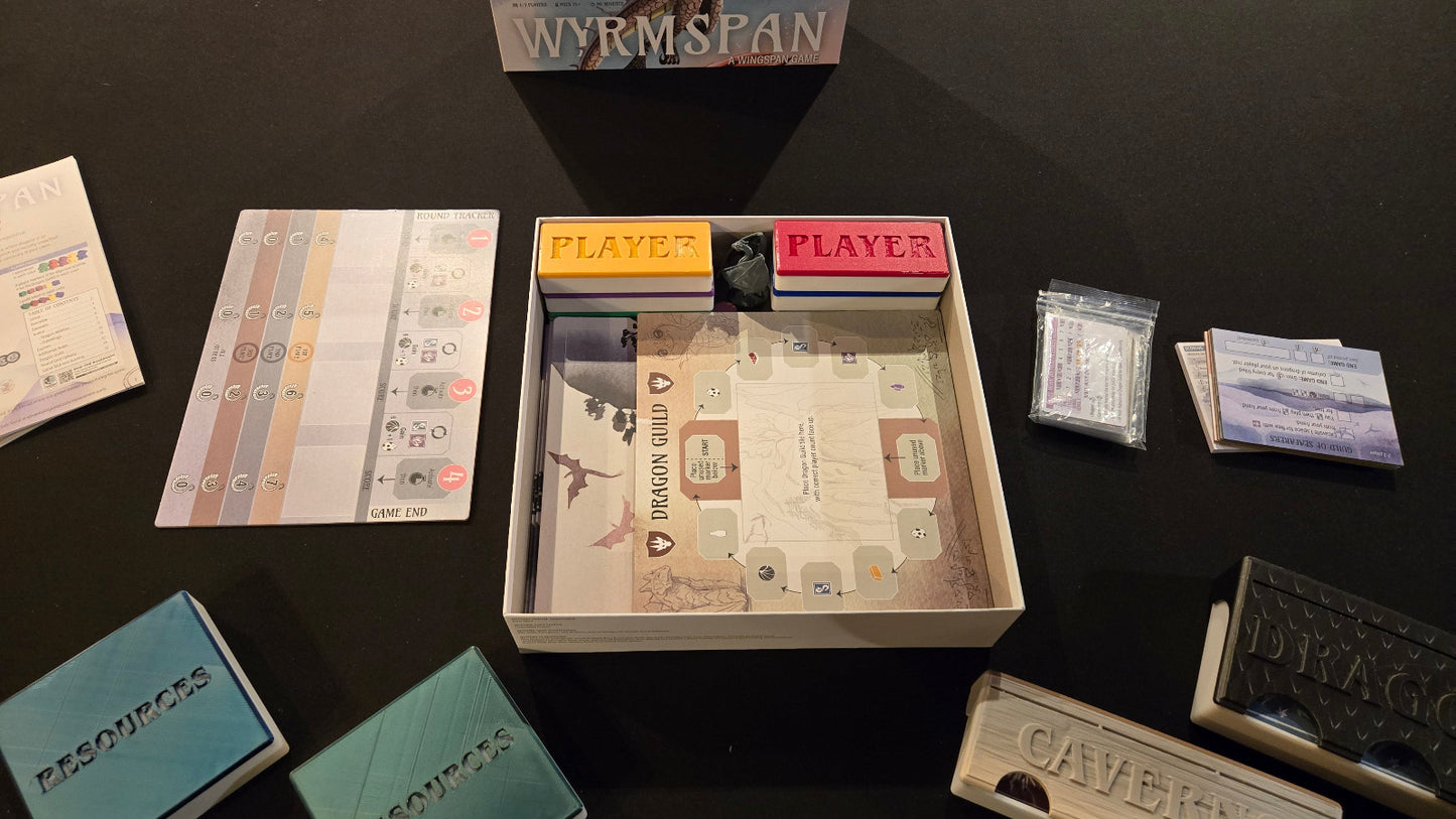 Board game components including cards, a map, and player tokens on a dark surface.