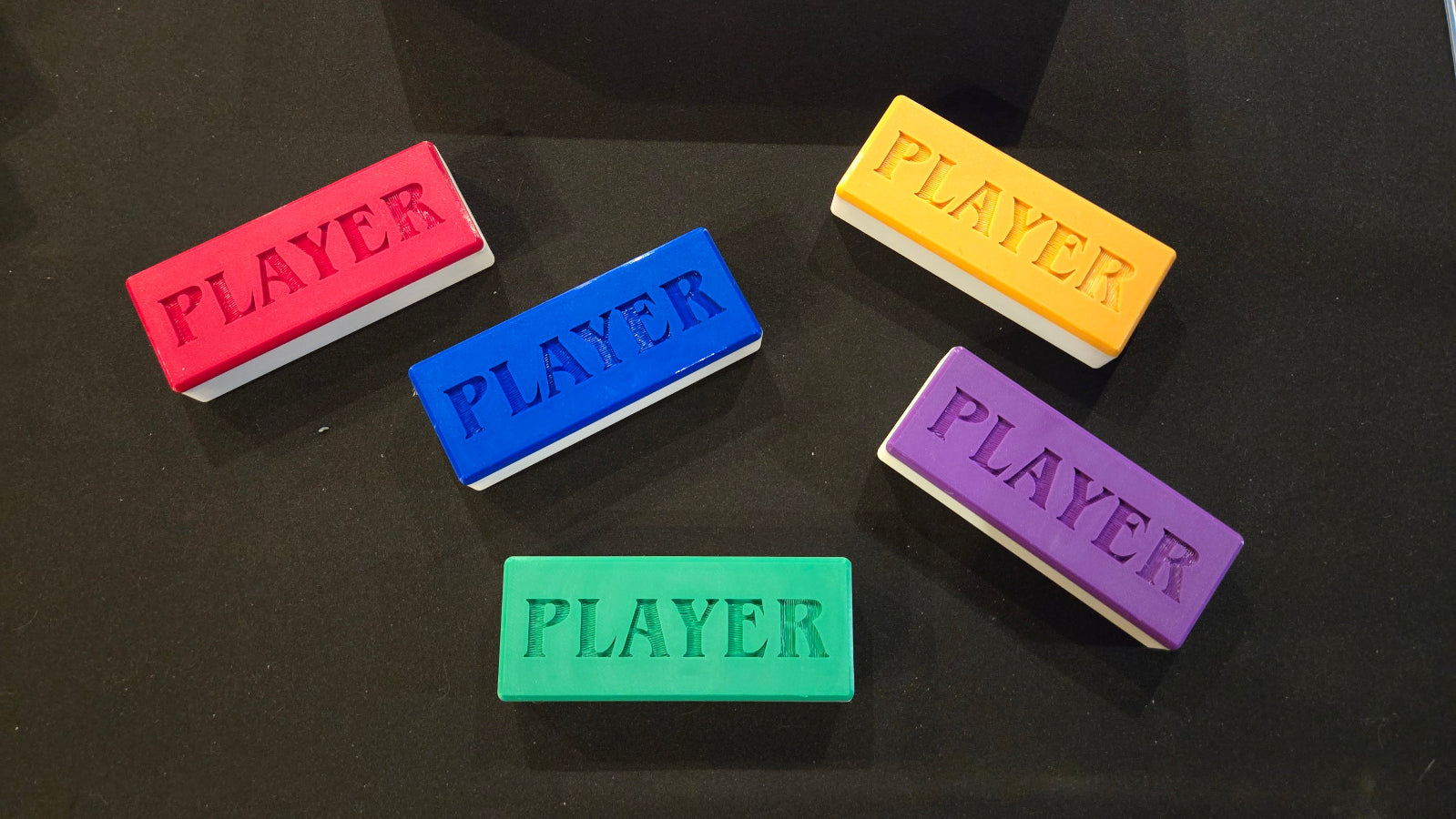 Five rectangular 'PLAYER' markers in different colors on a black background